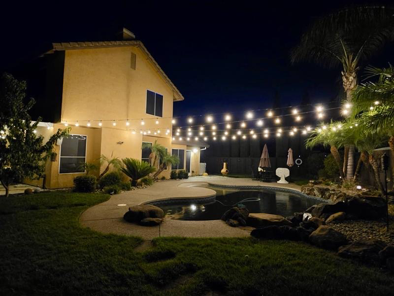 Commercial-grade bistro string lighting installed over a backyard patio in Sacramento