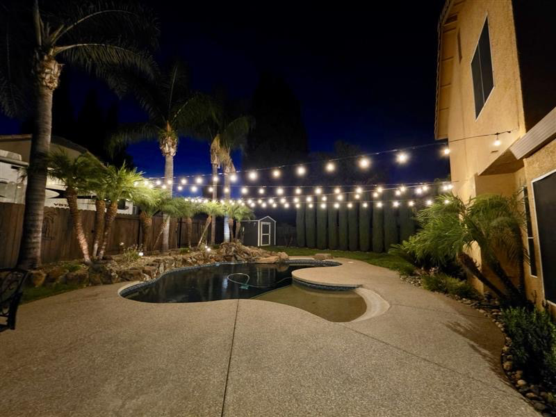 Aircraft cable supported bistro lighting over an outdoor kitchen in Land Park, Sacramento