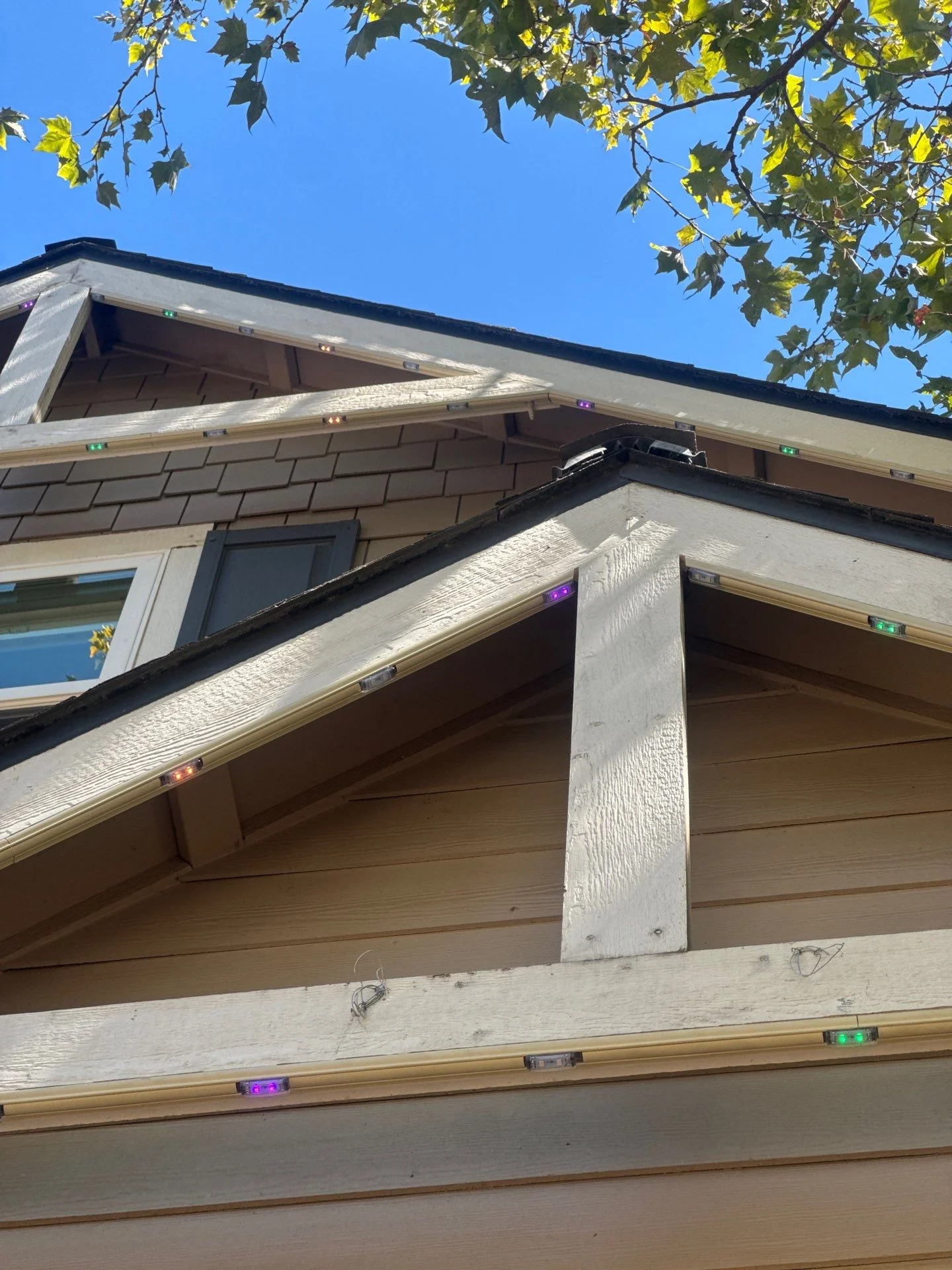 Sand colored permanent lighting track mounted on a white gable trim board in East Sacramento