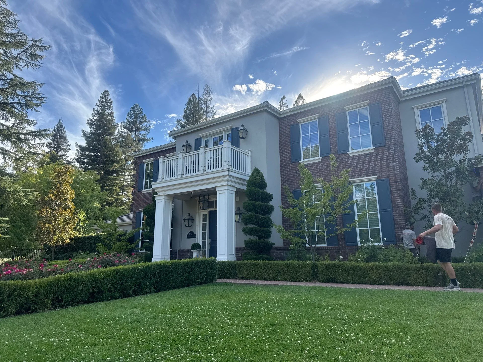 Two-story brick and stucco Georgian style home with white columns and balcony in Sacramento