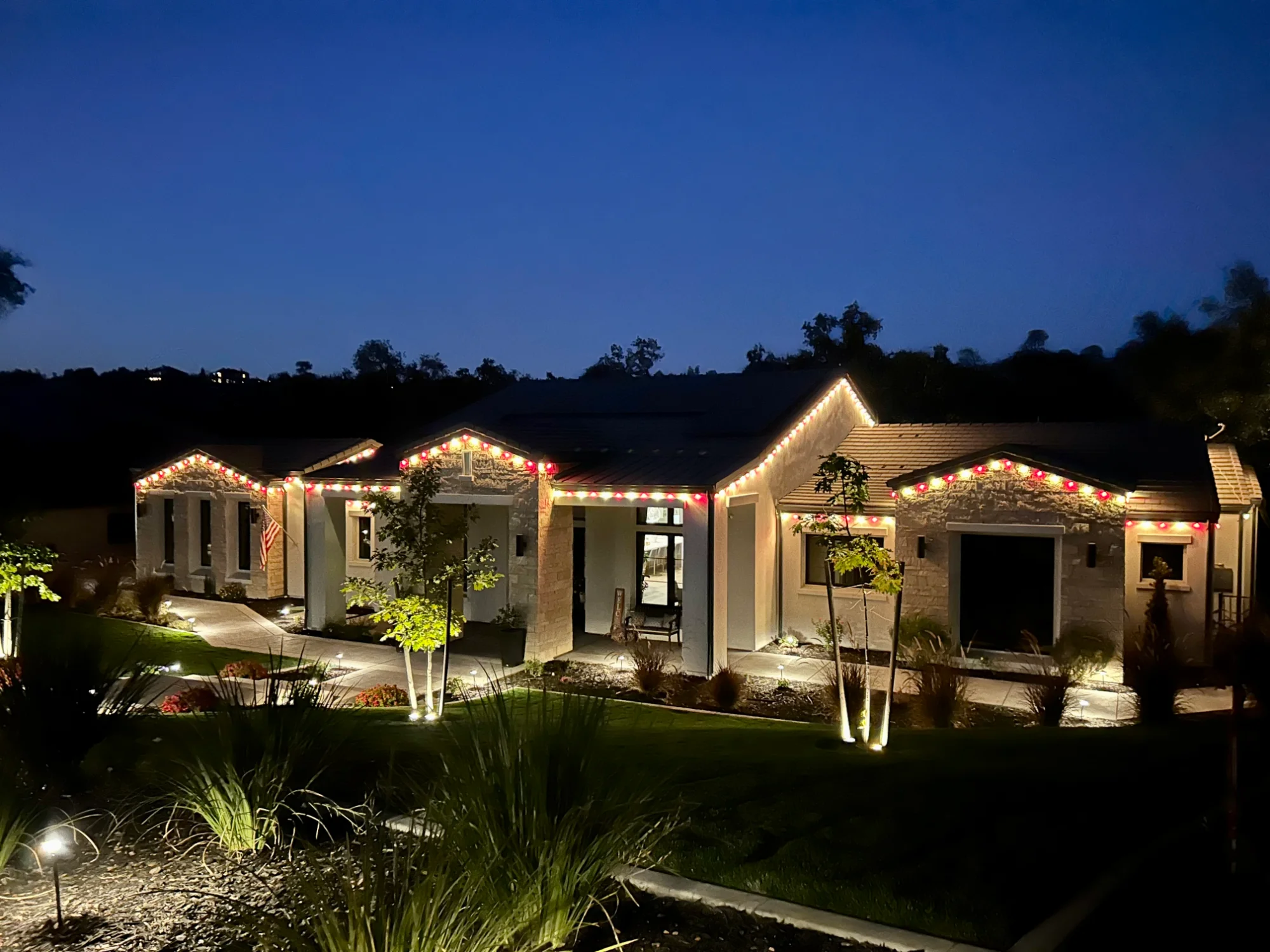 Sacramento home with Christmas lights turning on at dusk after professional installation